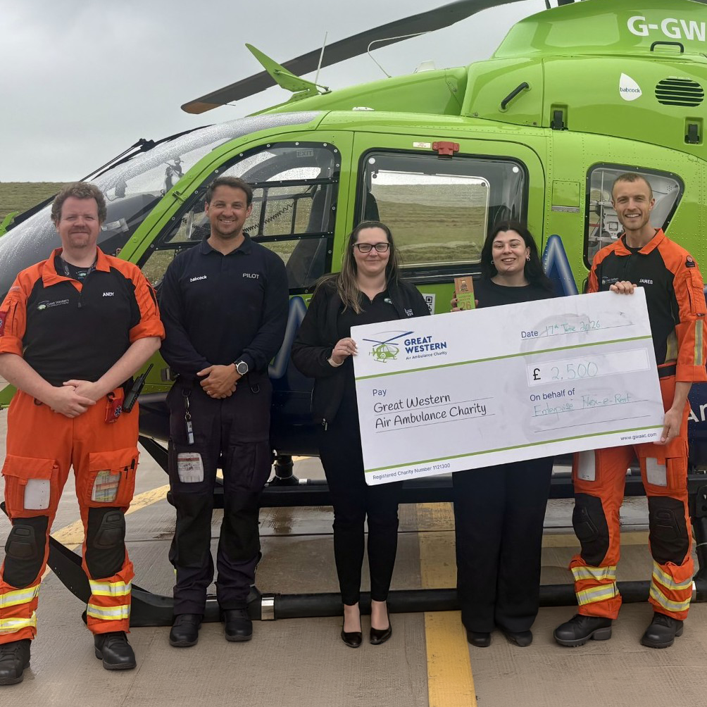 Representatives from Enterprise Flex-E-Rent present a donation cheque for £2,500 to Great Western Air Ambulance Charity crew members and pilot in front of the helimed helicopter