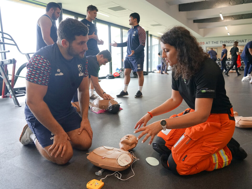 SPCC Fleur teaches a Bristol Bears rugby player how to use an AED