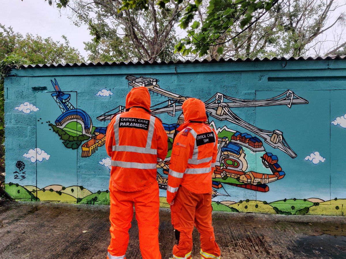 Two members of GWAAC's crew stand and look at the mural