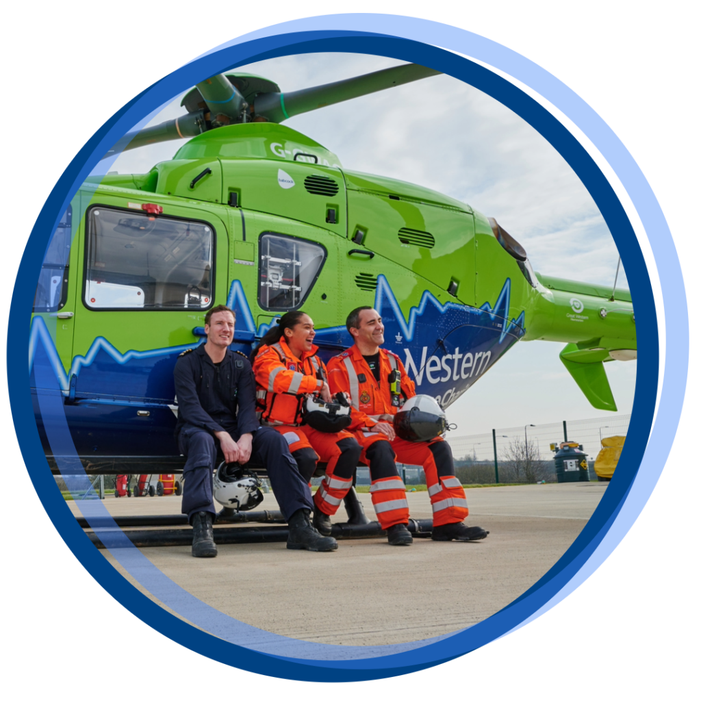 three paramedics sitting in front of a helicopter
