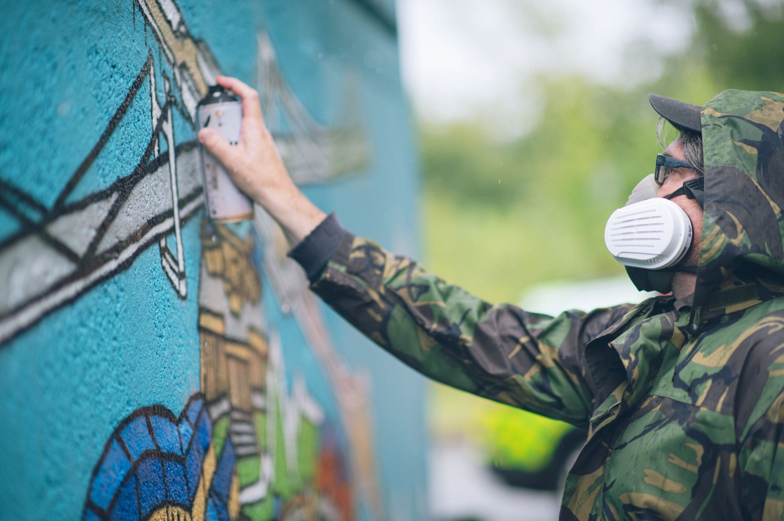 Andy spray painting the mural onto the wall