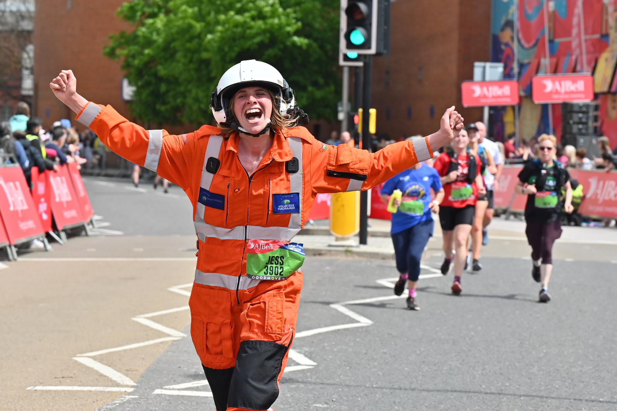 Woman in GWAAC flight suit and helmet running towards the finish line of the Great Bristol Run