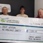 Carmen and her daughter Kirsty presenting GWAAC events manager Charlie with a giant cheque for £2,050