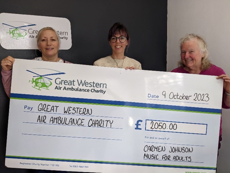 Carmen and her daughter Kirsty presenting GWAAC events manager Charlie with a giant cheque for £2,050