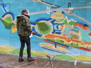 Andy Council spraying his helicopter mural at the GWAAC airbase