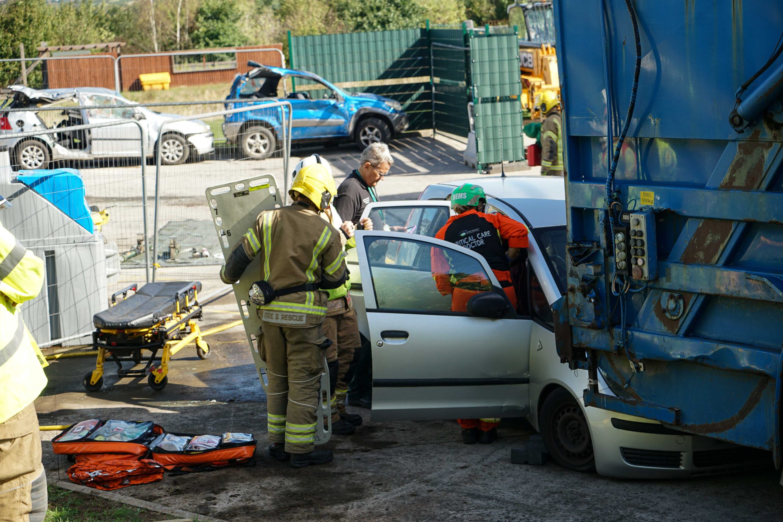 Members of the fire service prepare to extricate a patient that is trapped in their car as a member of the Great Western Air Ambulance Charity Critical Care Team looks in through the door.