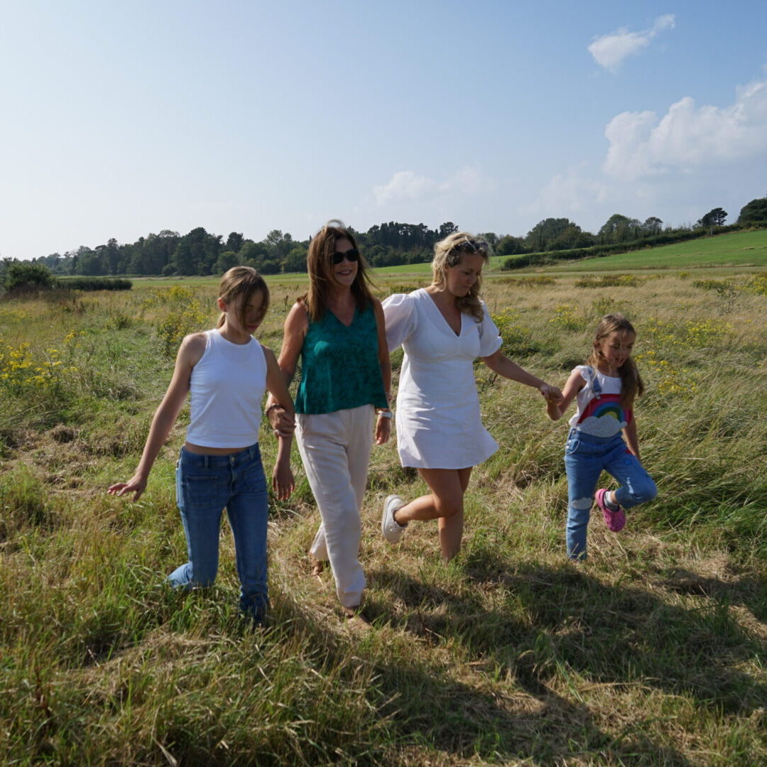 former patient ann walking across a field with her family
