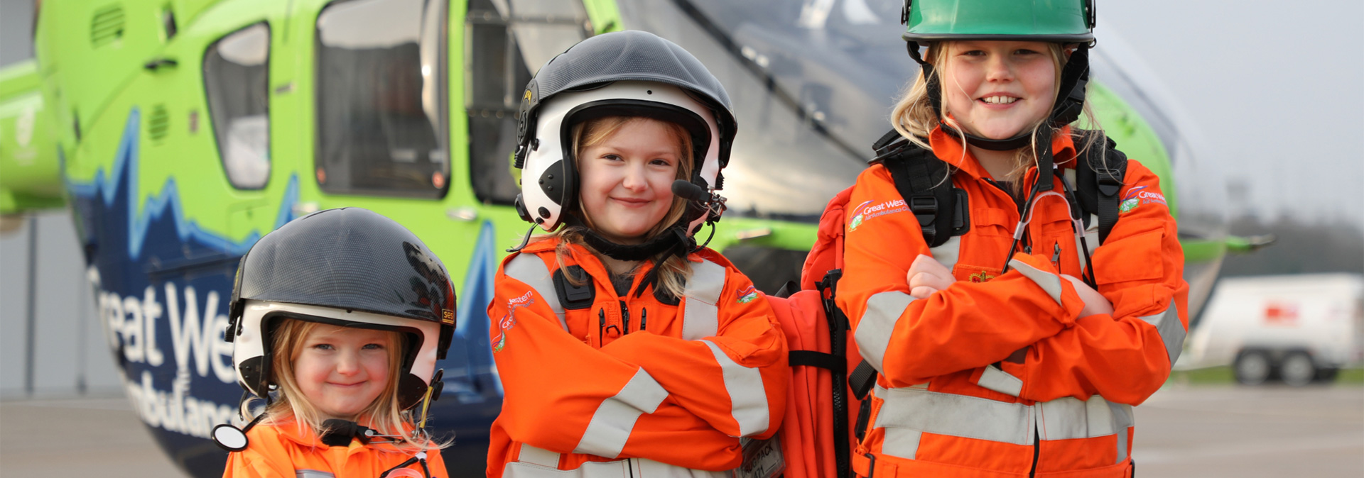 THree young girls dressed up in GWAAC crew jackets and flight helmets