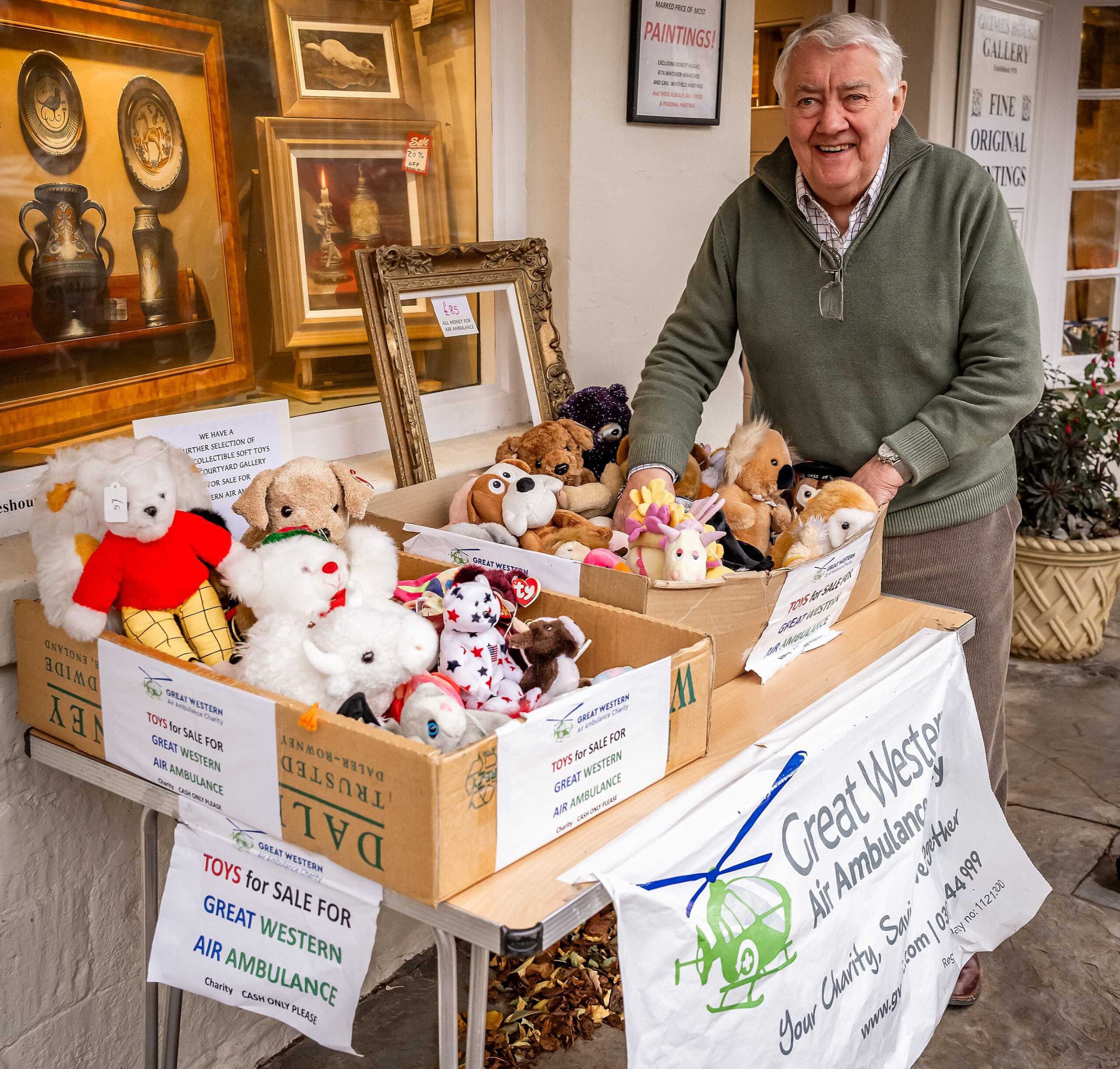 A man displays picture frames and vintage soft toys at Grimes House Gallery to raise money for GWAAC