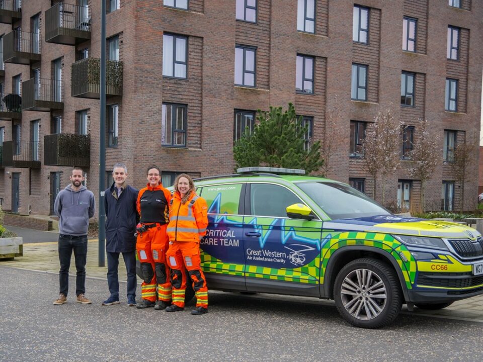 SPCC Fleur and Criitcal Care Doctor Sophie with Partnerships Manager Joe and members of the brabazon team in front of a critical care car in the new Filton development.