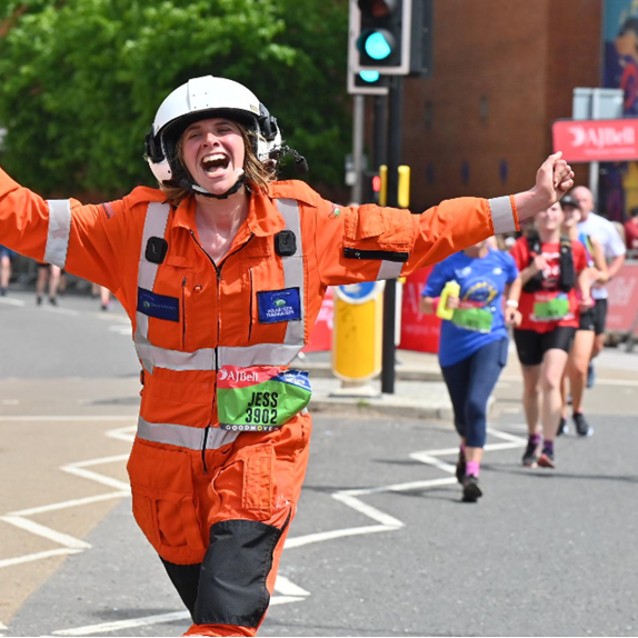 Runner Jess nearing the finish of the Great Bristol Run in GWAAC flightsuit and helmet