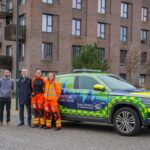 SPCC Fleur and Criitcal Care Doctor Sophie with Partnerships Manager Joe and members of the brabazon team in front of a critical care car in the new Filton development.