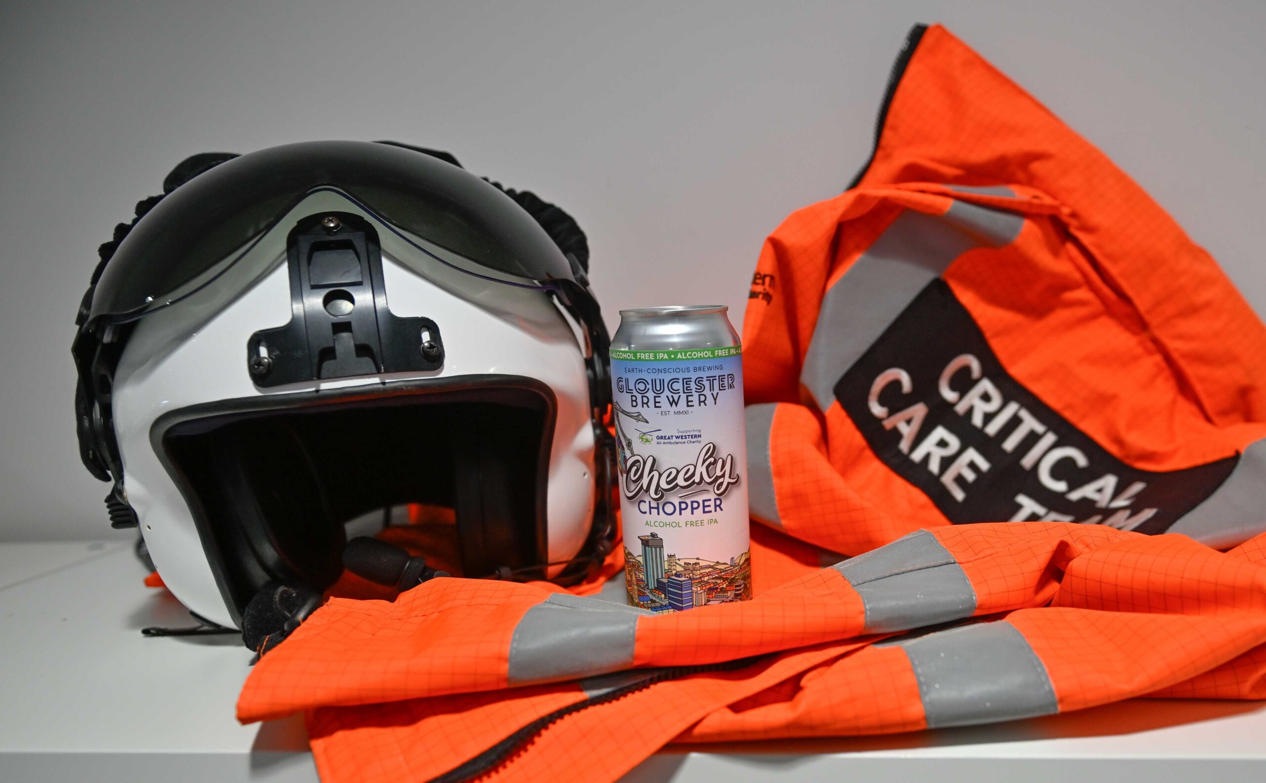 A can of Cheeky Chopper in between a GWAAC flight helmet and jacket