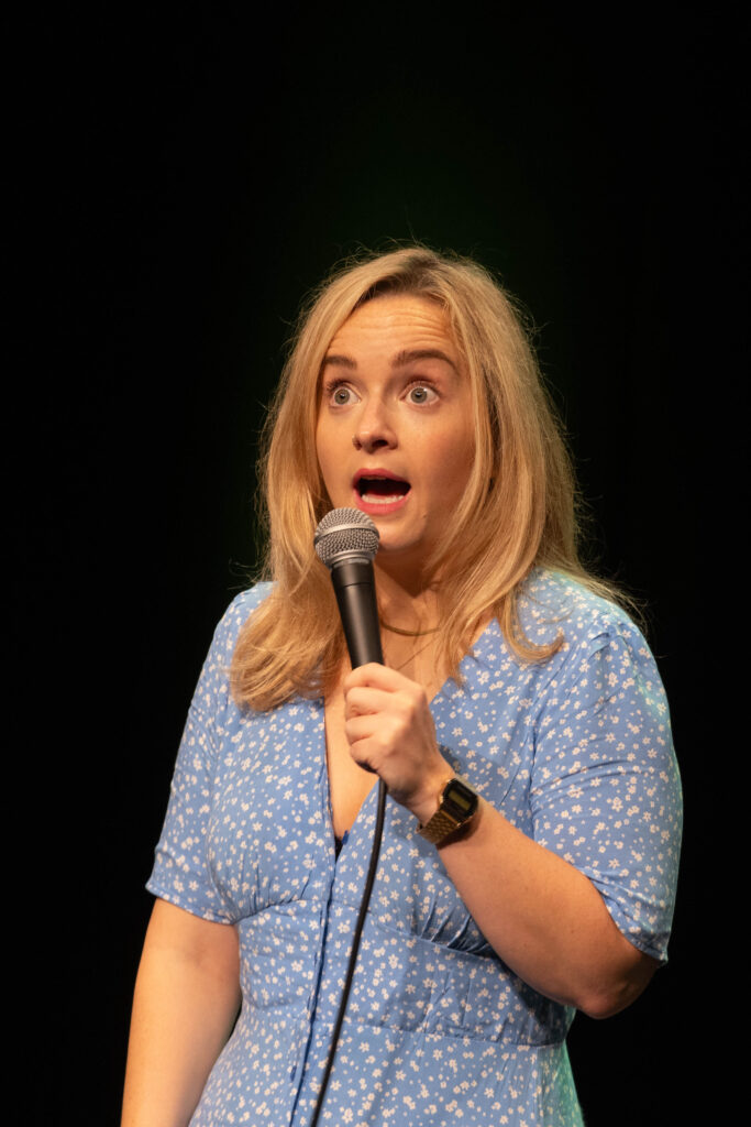 Comedian Julia Stenton pulling a face while performing at Heli Laughs 2023 at The Old Vic Bristol