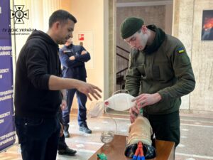 SPCC Matt teaches skills to a Ukrainian soldier using a manikin.